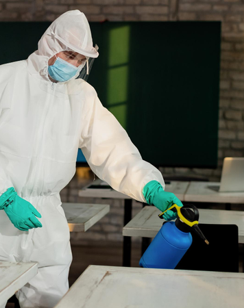 Professional pest technician treating classroom surfaces – Angel City Pests