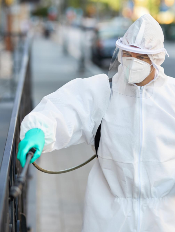 Pest technician spraying exterior railing for pest prevention – Angel City Pests