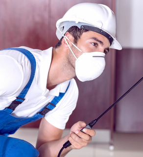 Professional pest technician applying treatment indoors – Angel City Pests